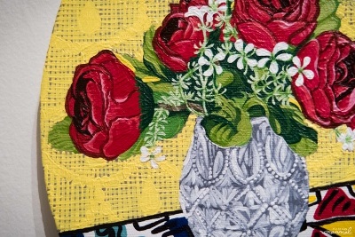Circular painting of a bouquet of red roses in a glass vase against a yellow background