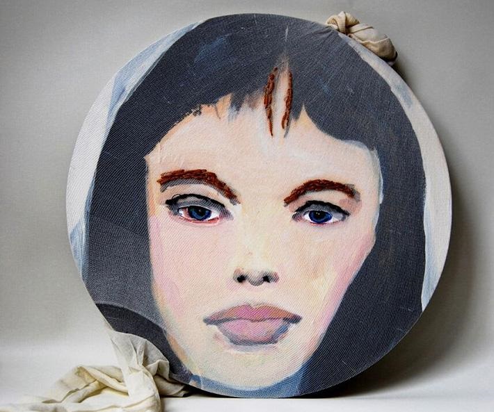 Circular portrait painting of a woman with threads sewn in her eyebrows and hair by Linda Brescia