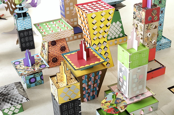 Sculptures of buildings made out of different colourful recycled cardboard and mixed media
