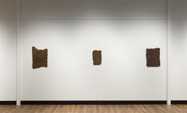 Three square copper tablets with inscriptions on the gallery wall
