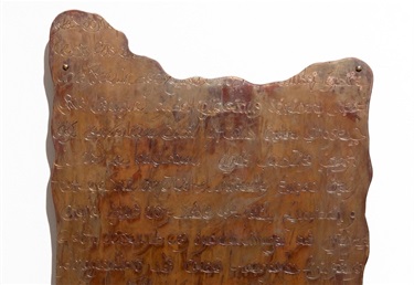 Close up of engraved copper tablet with French, Arabic and English writing