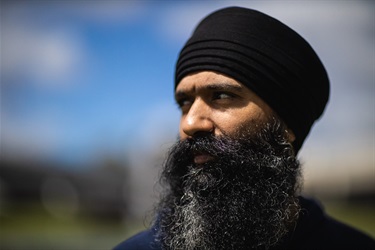 Close up portrait of a bearded man wearing a sikh turban staring away from the camera