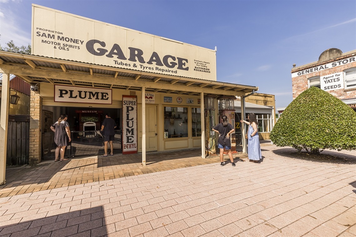 Visitors observing an old garage display at FCMG including a large truck