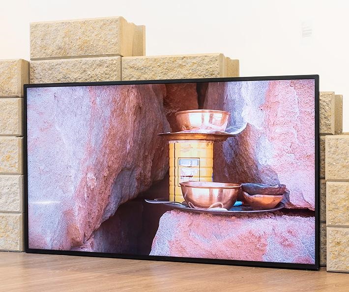 Video installation propped against a pile of sandstock bricks
