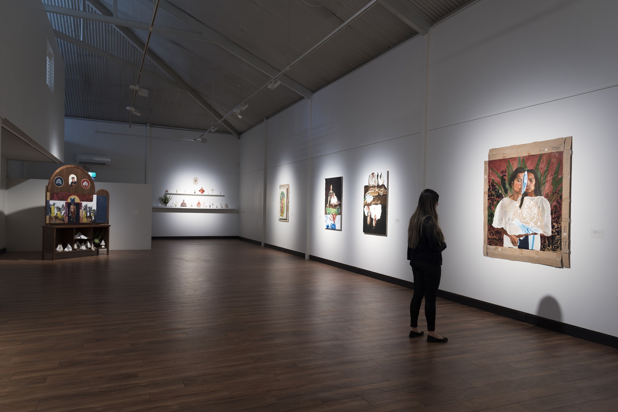 women looking at artwork on the wall in gallery