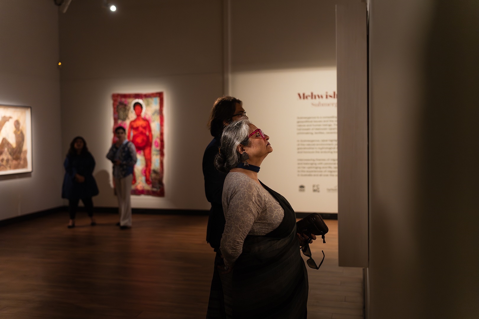 woman looking at artwork by artist Mehwish Iqbal in the gallery