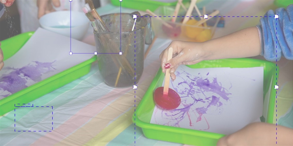 Kids hands painting with coloured ice 