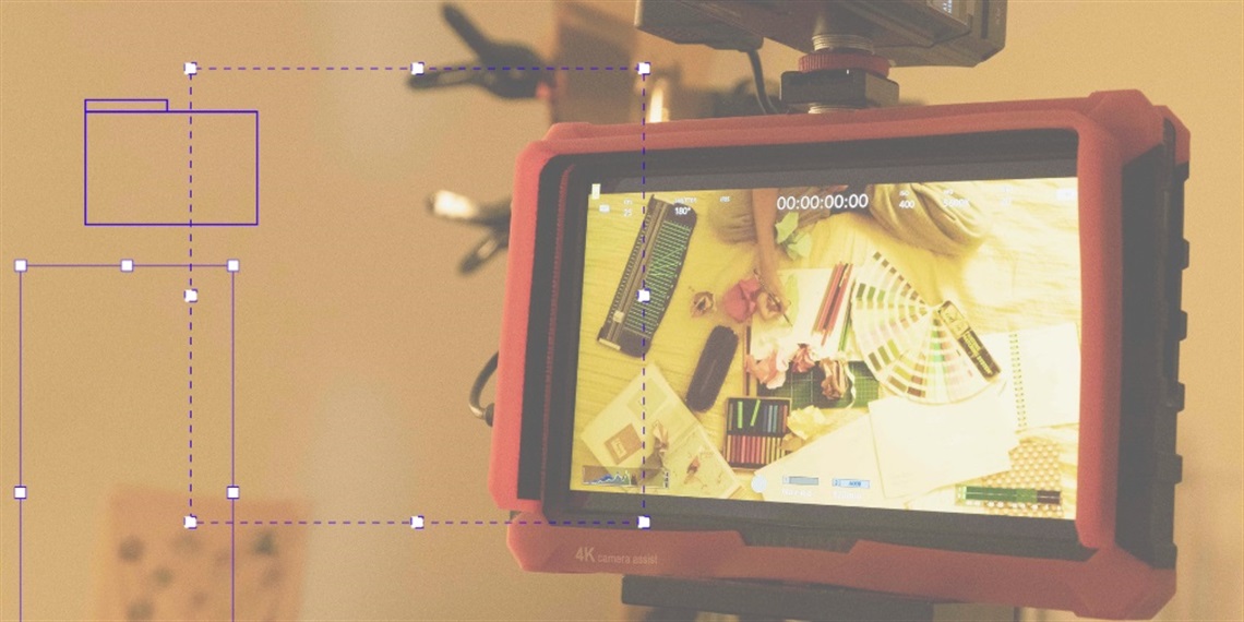 A camera monitor showing art supplies on a bed
