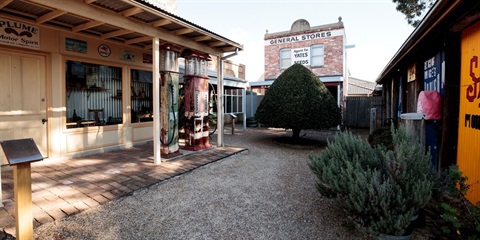 Photograph of Money's Motor Garage, The Biz, Wheatley's General Store and the bay tree at the Vintage Village