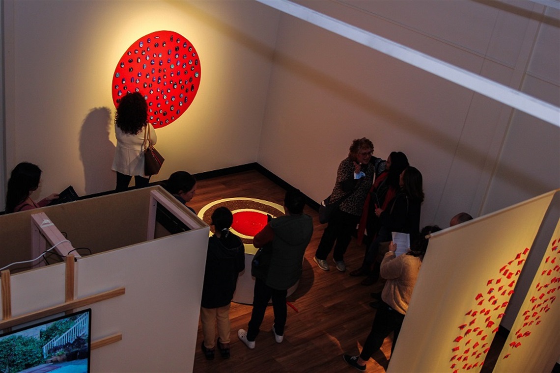 Image of guests viewing two artworks from re-member exhibition